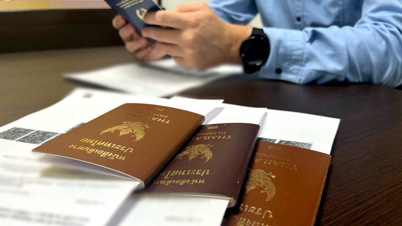 A Workmigration specialist reviews foreign workers' passports and work permits