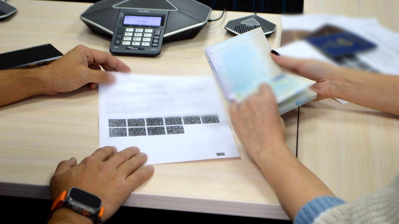 A permit to hire foreign labour on a desk next to a passport with a work visa