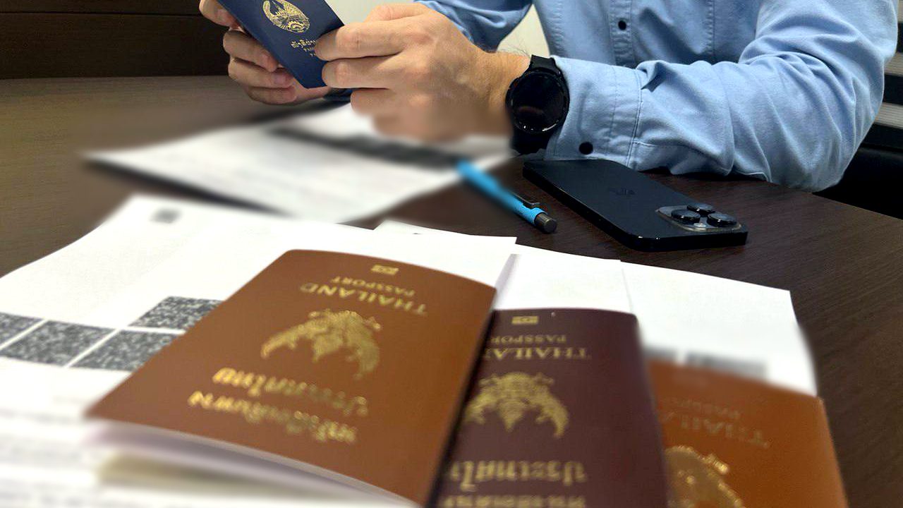 Workmigration маманы визаны ауыстыру үшін шетелдік жұмыскердің төлқұжаты мен құжаттарын қарап жатыр